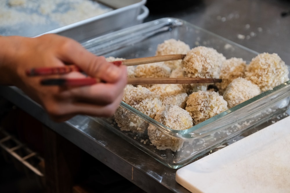 person holding clear plastic container with white rice