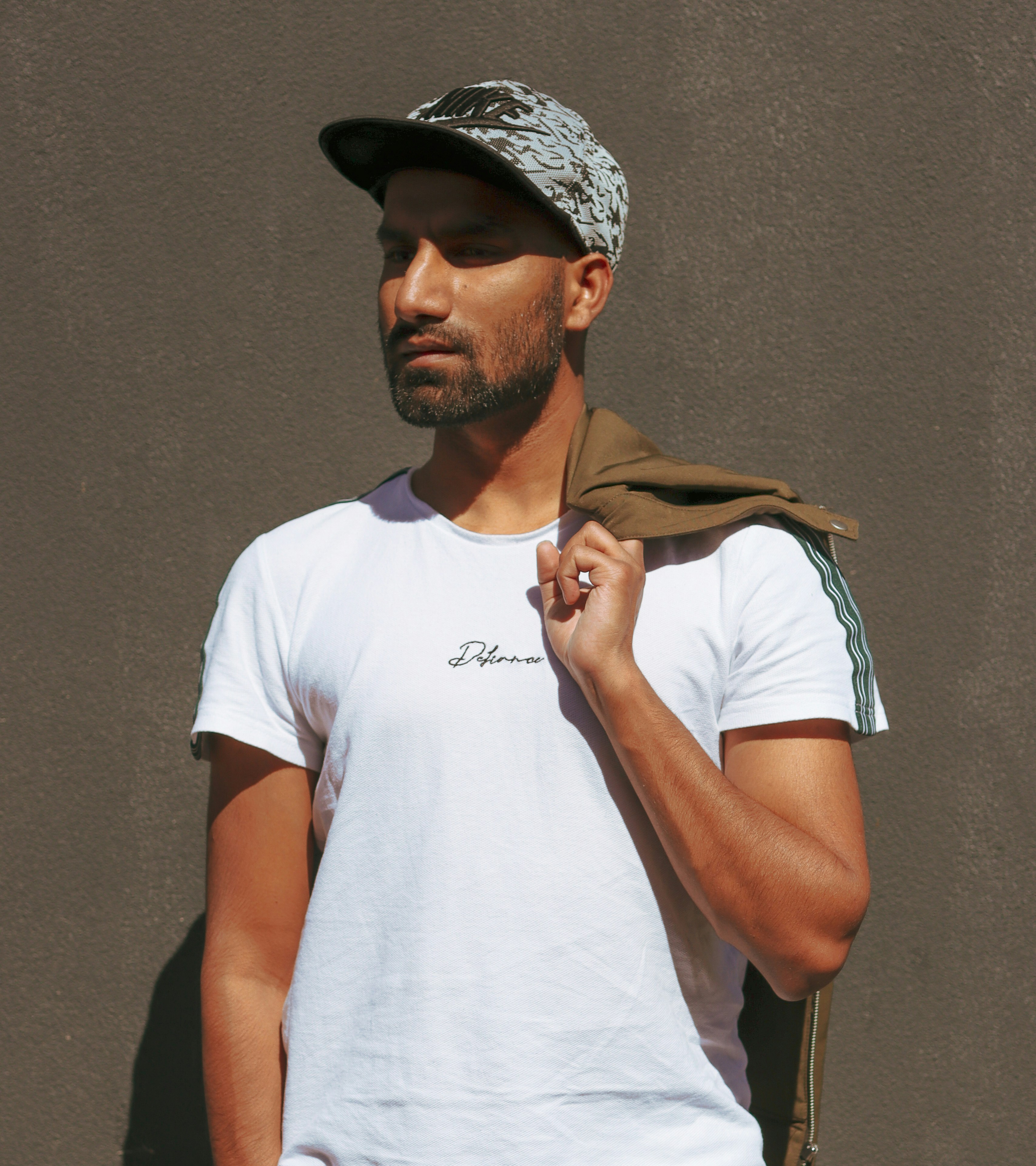 흰색 크루넥 티셔츠와 갈색 재킷을 입은 남자