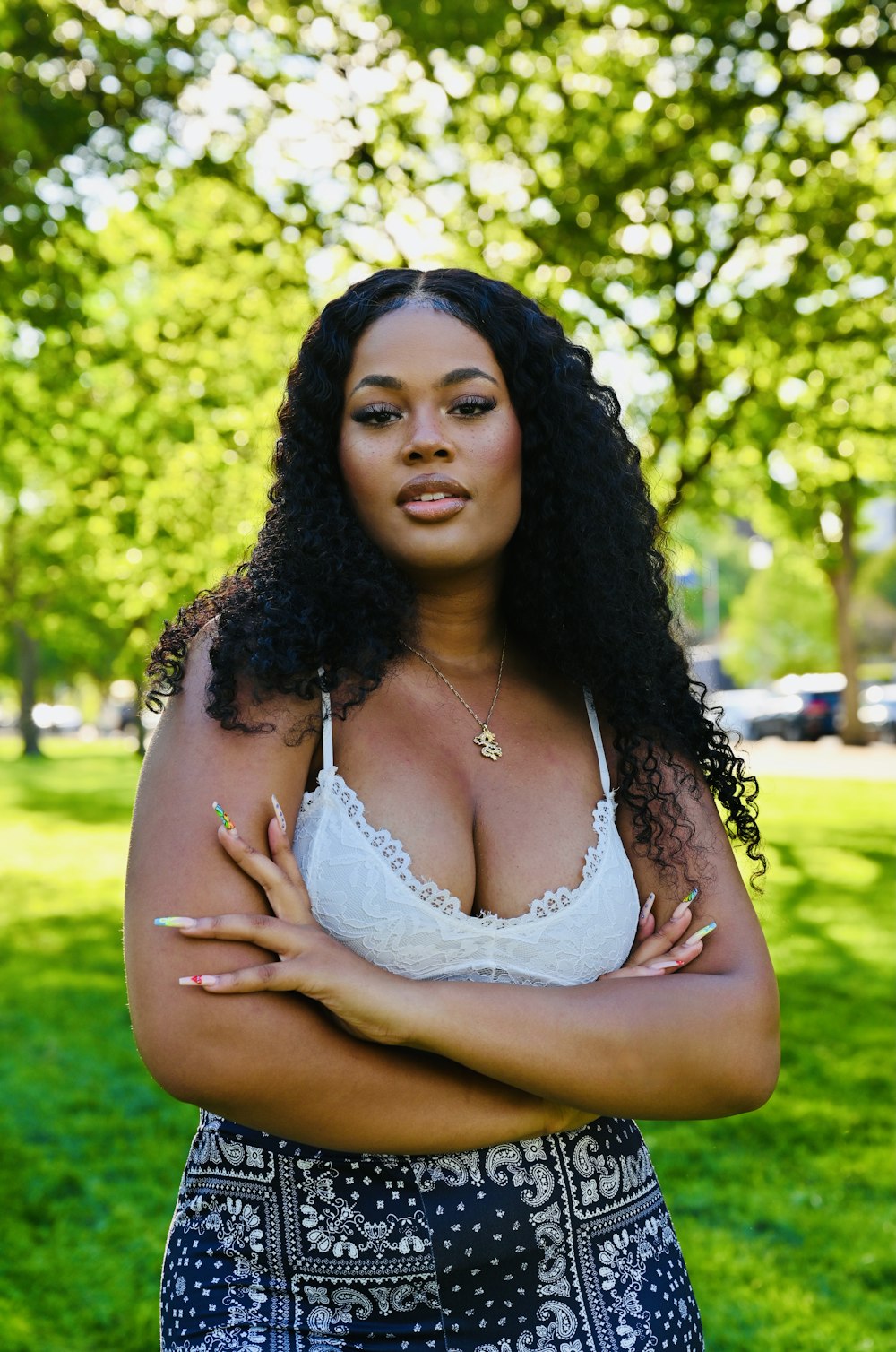 woman in white floral lace brassiere standing on green grass field during daytime