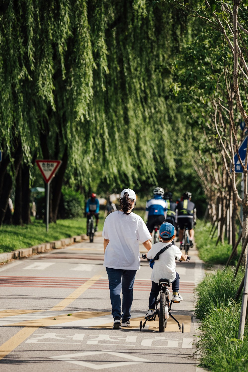 man in white shirt riding bicycle on road during daytime