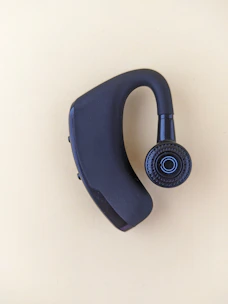 A close-up of a discreet earpiece worn by a female operative blending into a corporate event.