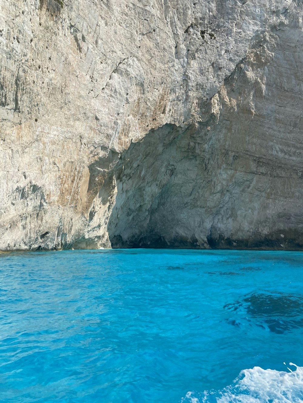 Montagna rocciosa marrone accanto al mare blu durante il giorno