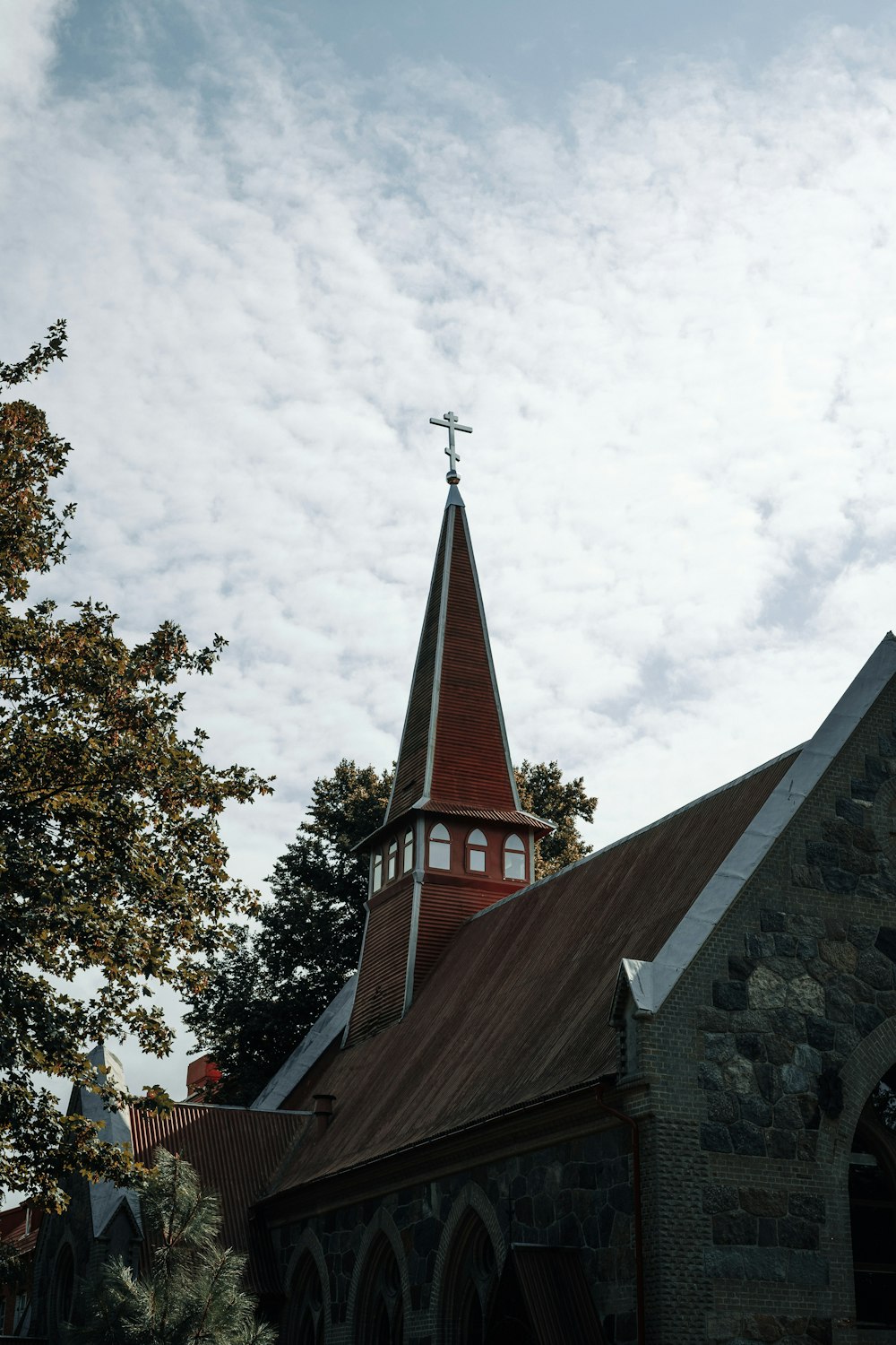 une église avec un clocher et une croix au sommet