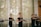 A group of women practicing martial arts in a well-lit room, each holding a wooden or bamboo training weapon. They are wearing matching black attire and appear focused and coordinated, suggesting a structured training session.