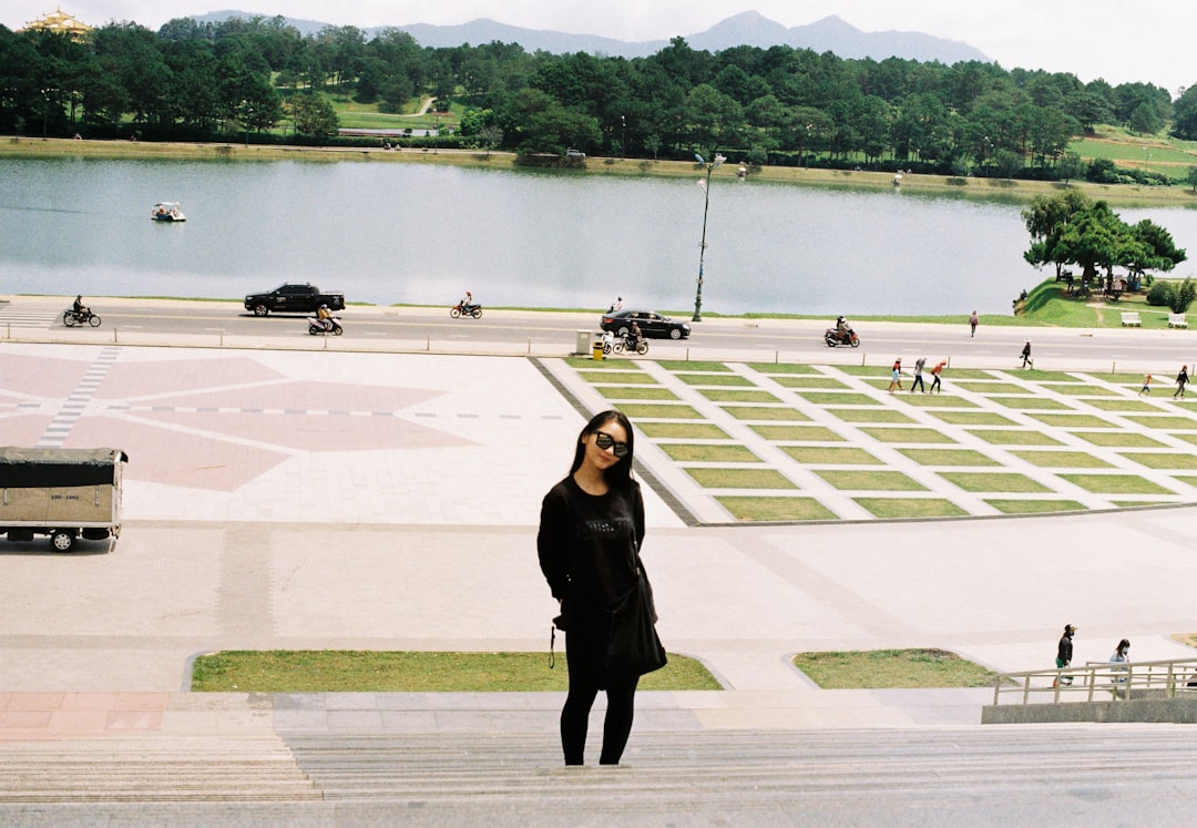 woman in black long sleeve dress standing on brown and white field during daytime