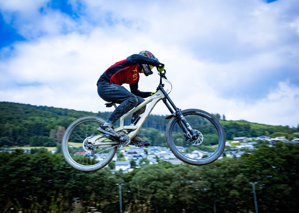 man in black jacket riding on mountain bike during daytime