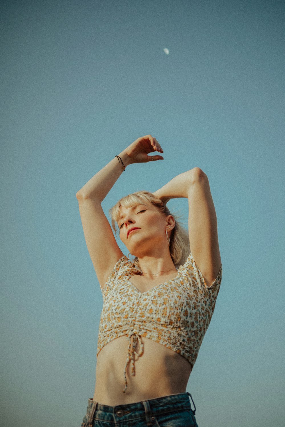 a woman in a leopard print top is holding her arms up