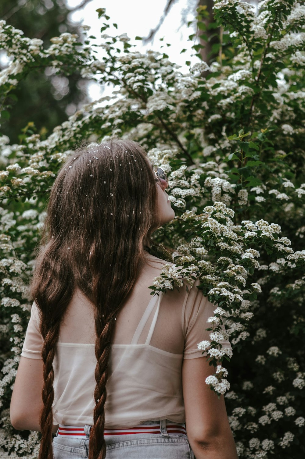 woman in white shirt standing near green plant during daytime