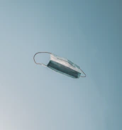 Softly lit image of a person releasing a paper mask into the wind, symbolizing freedom.