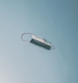 Softly lit image of a person releasing a paper mask into the wind, symbolizing freedom.