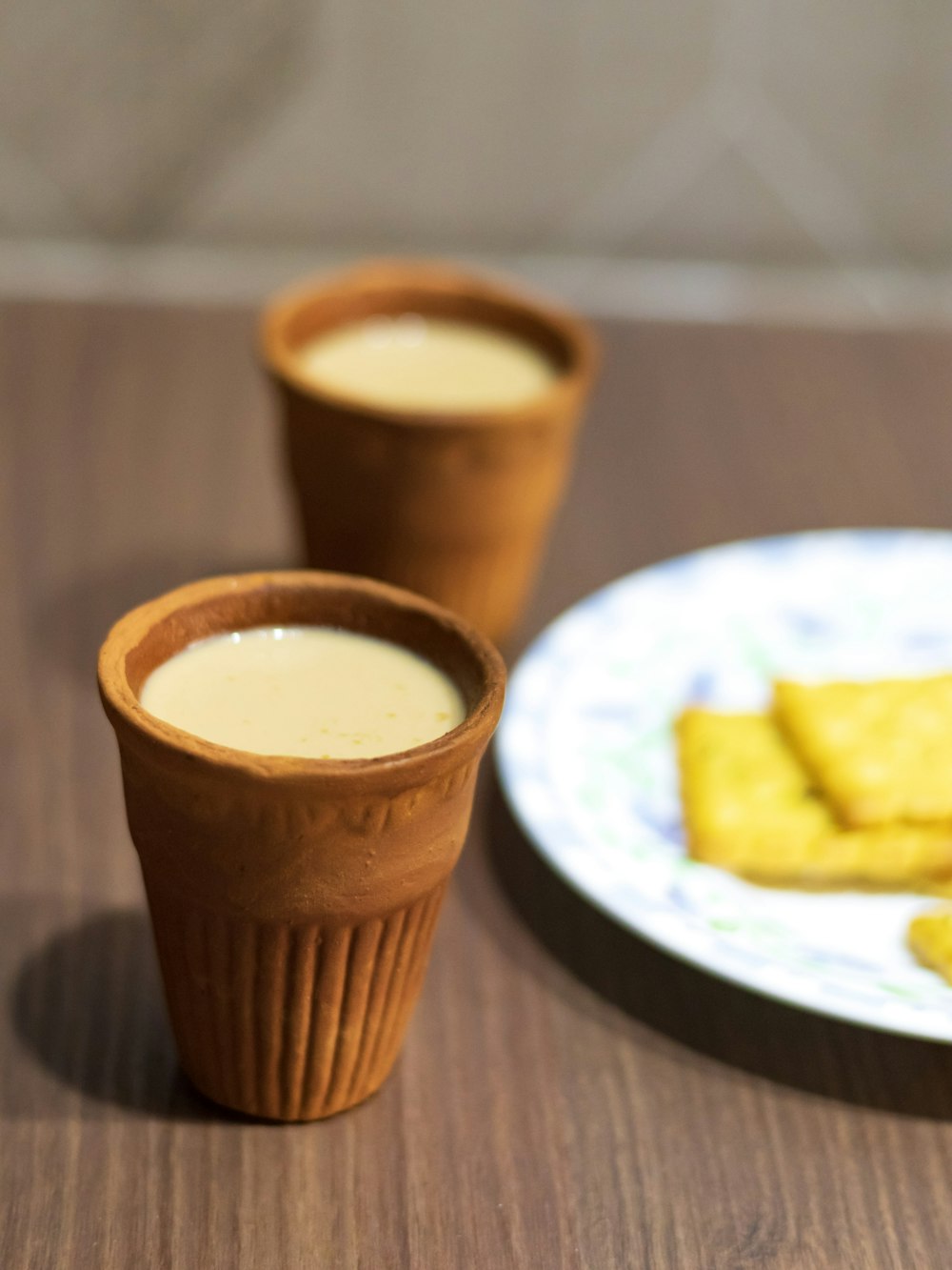 brown cup on white and blue ceramic plate