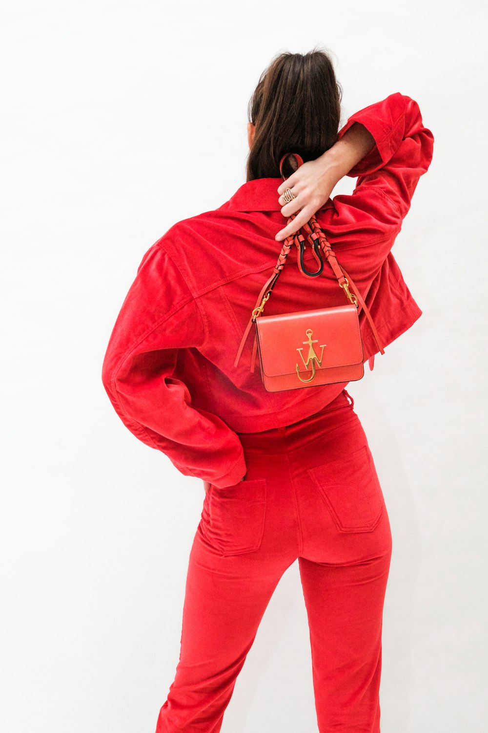 woman in red long sleeve shirt and red pants carrying brown leather handbag