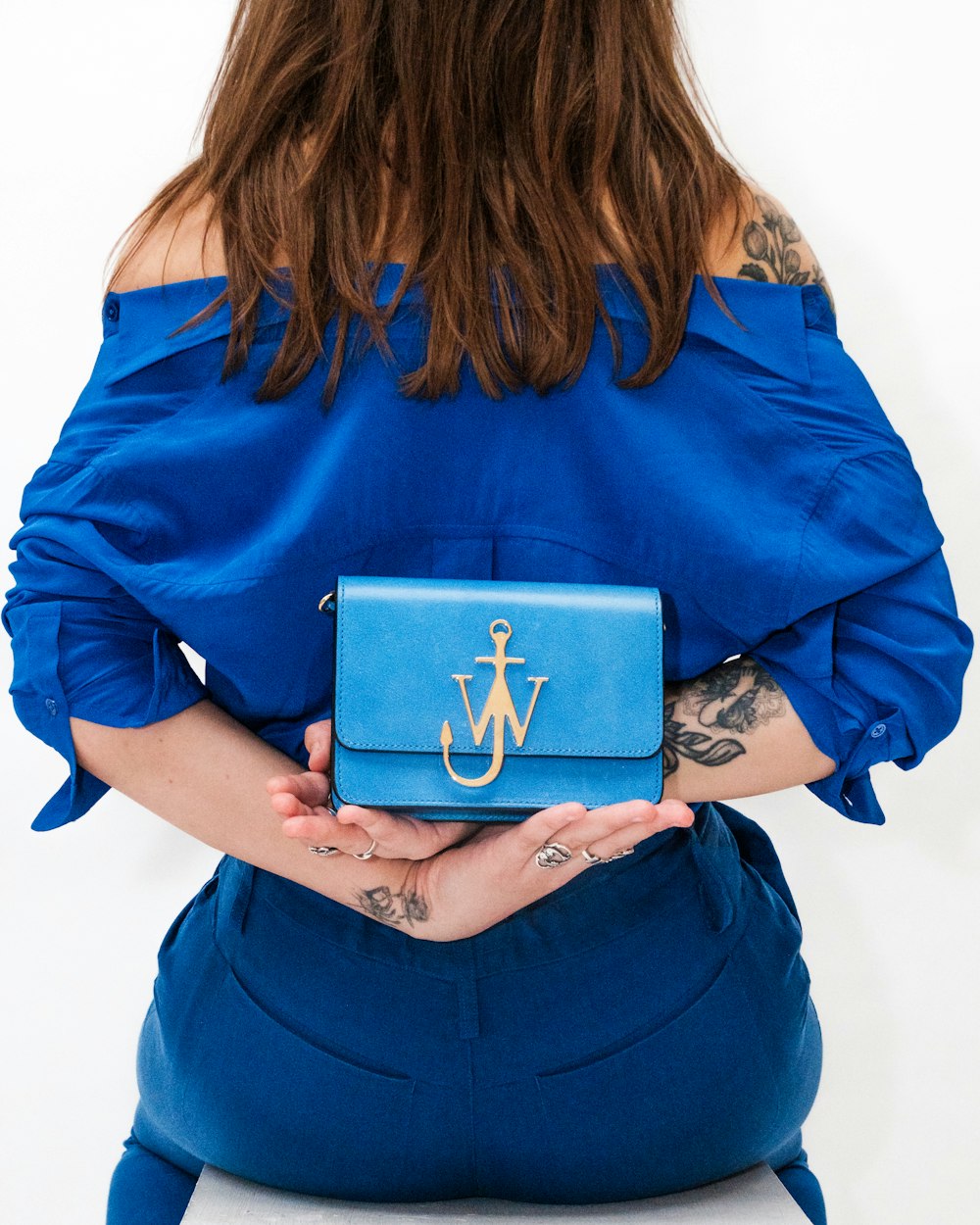 woman in blue long sleeve shirt holding blue book