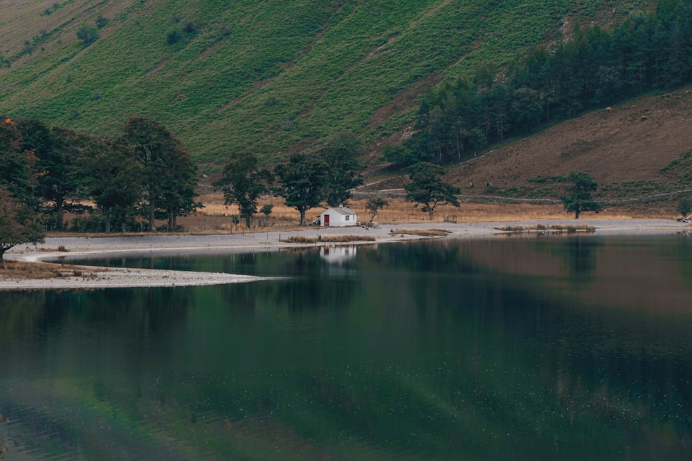 green mountain beside body of water during daytime