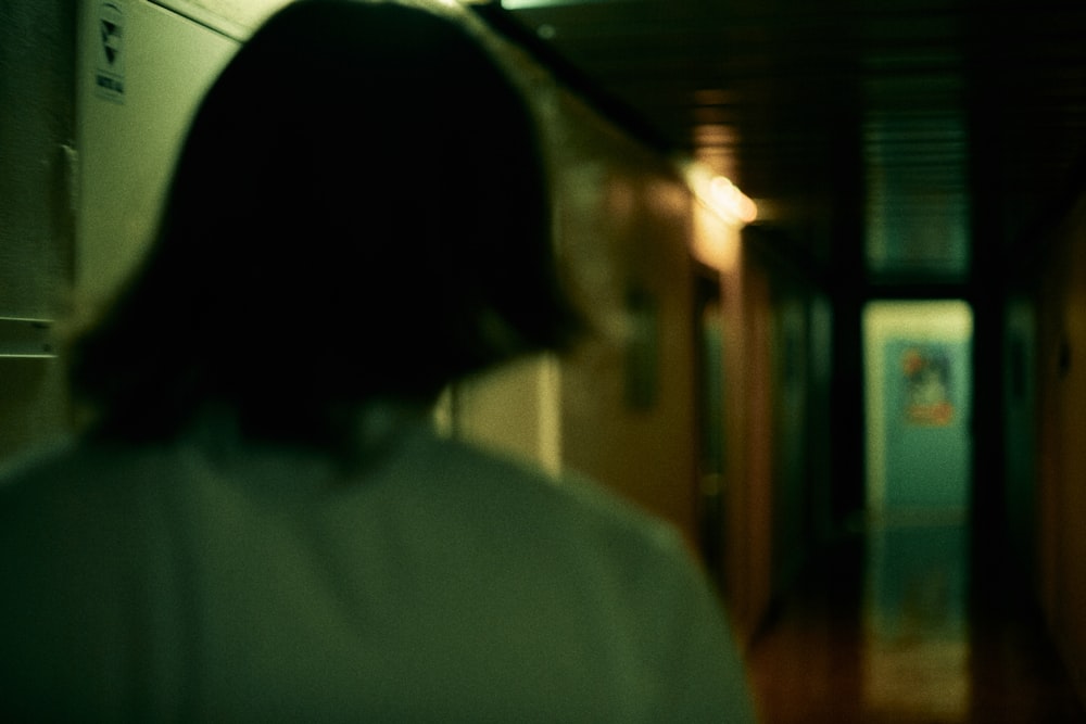 Frau im weißen Hemd steht neben brauner Holztür