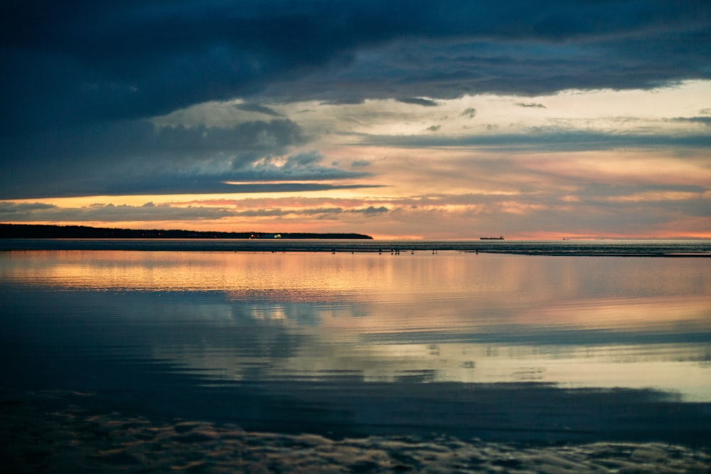 body of water under cloudy sky during daytime