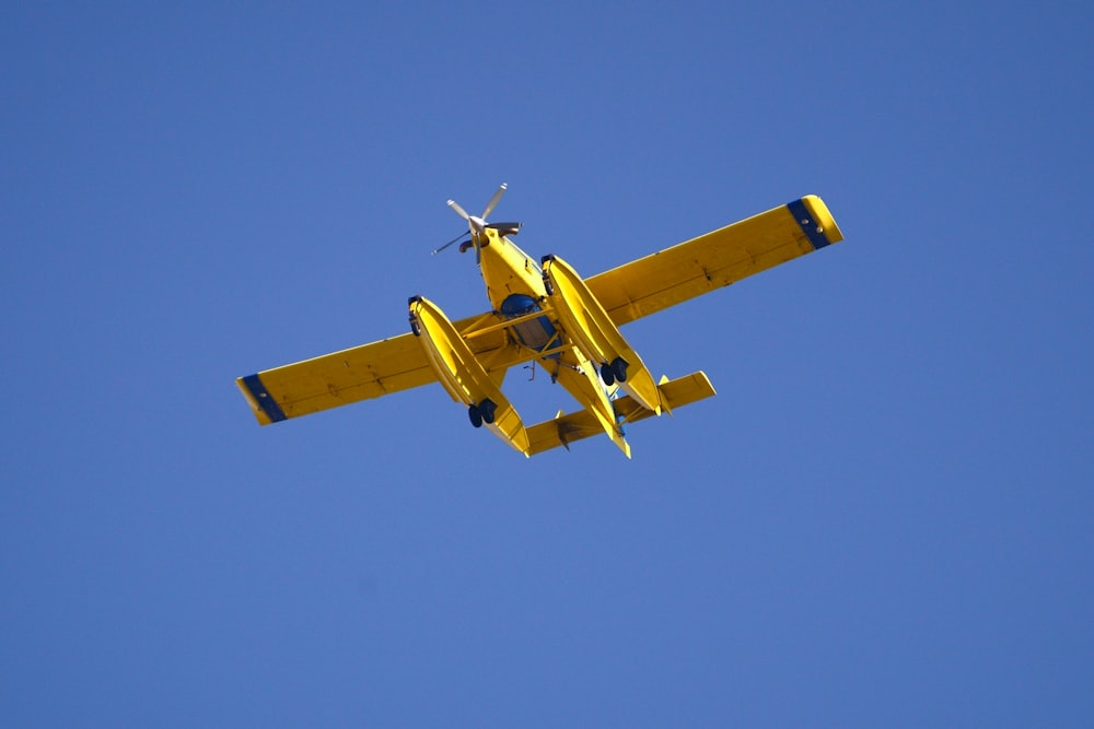 yellow and black plane in mid air under blue sky during daytime