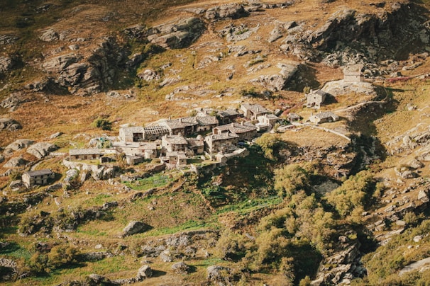 A rustic village square bathed in golden light where Bernard tells a story to a circle of listeners.