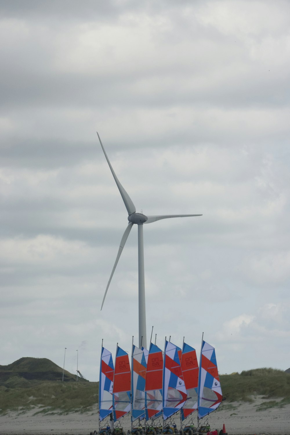 white wind turbine under gray sky