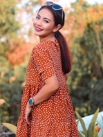 woman in red and white polka dot dress wearing black hat
