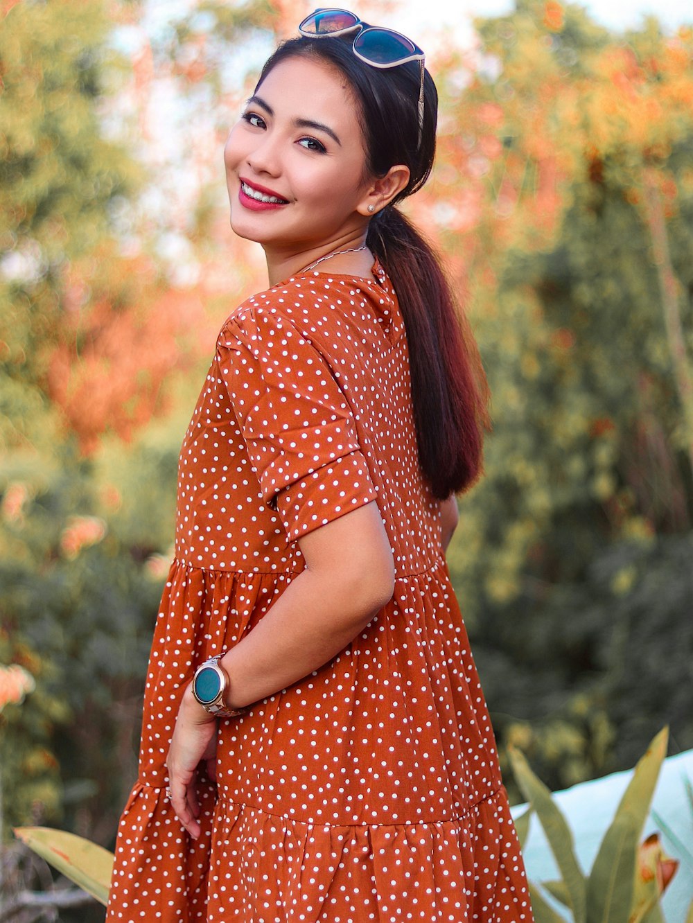 woman in red and white polka dot dress wearing black hat