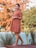 woman in red and white polka dot dress standing near green plants during daytime