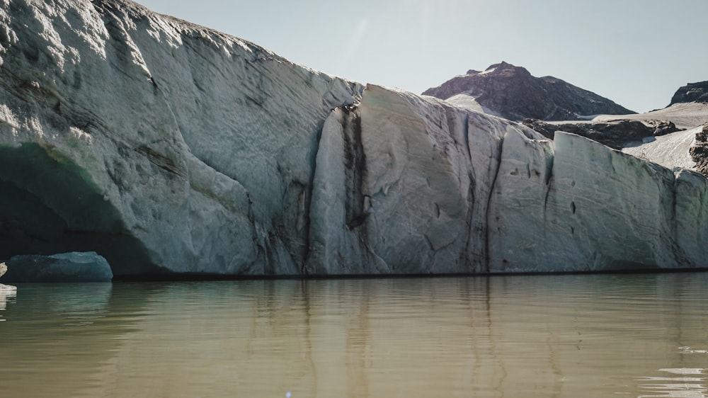 gray rock formation on body of water during daytime