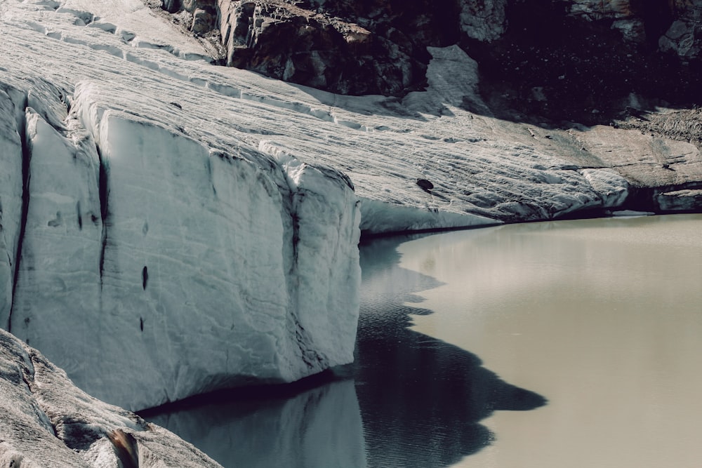 body of water between rocky mountains during daytime