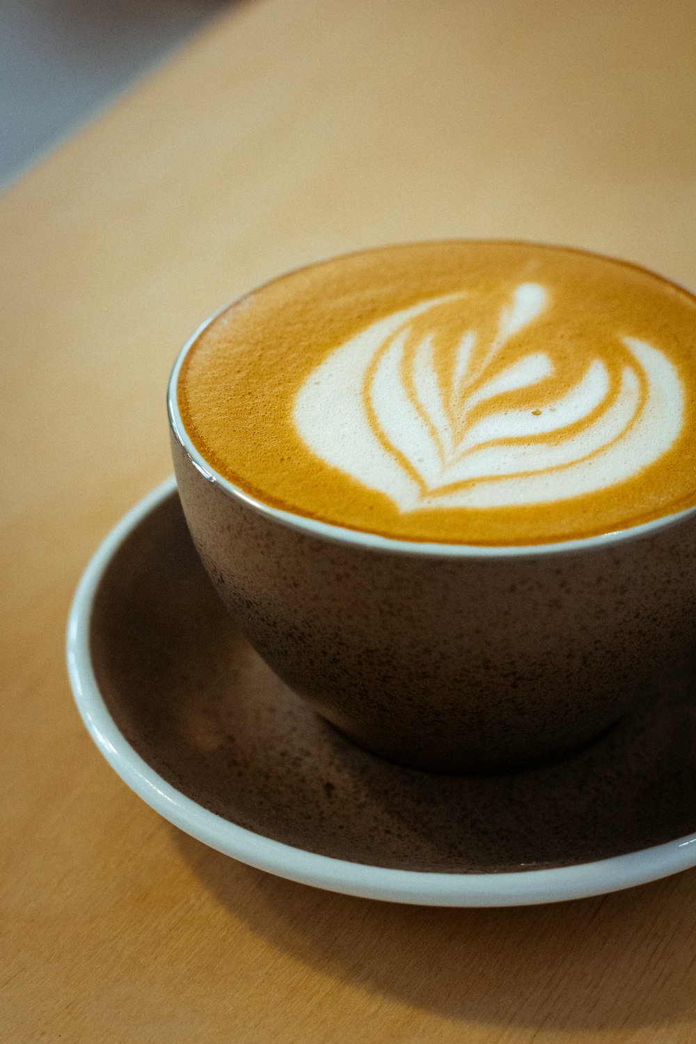 white ceramic cup with brown and white heart shaped coffee