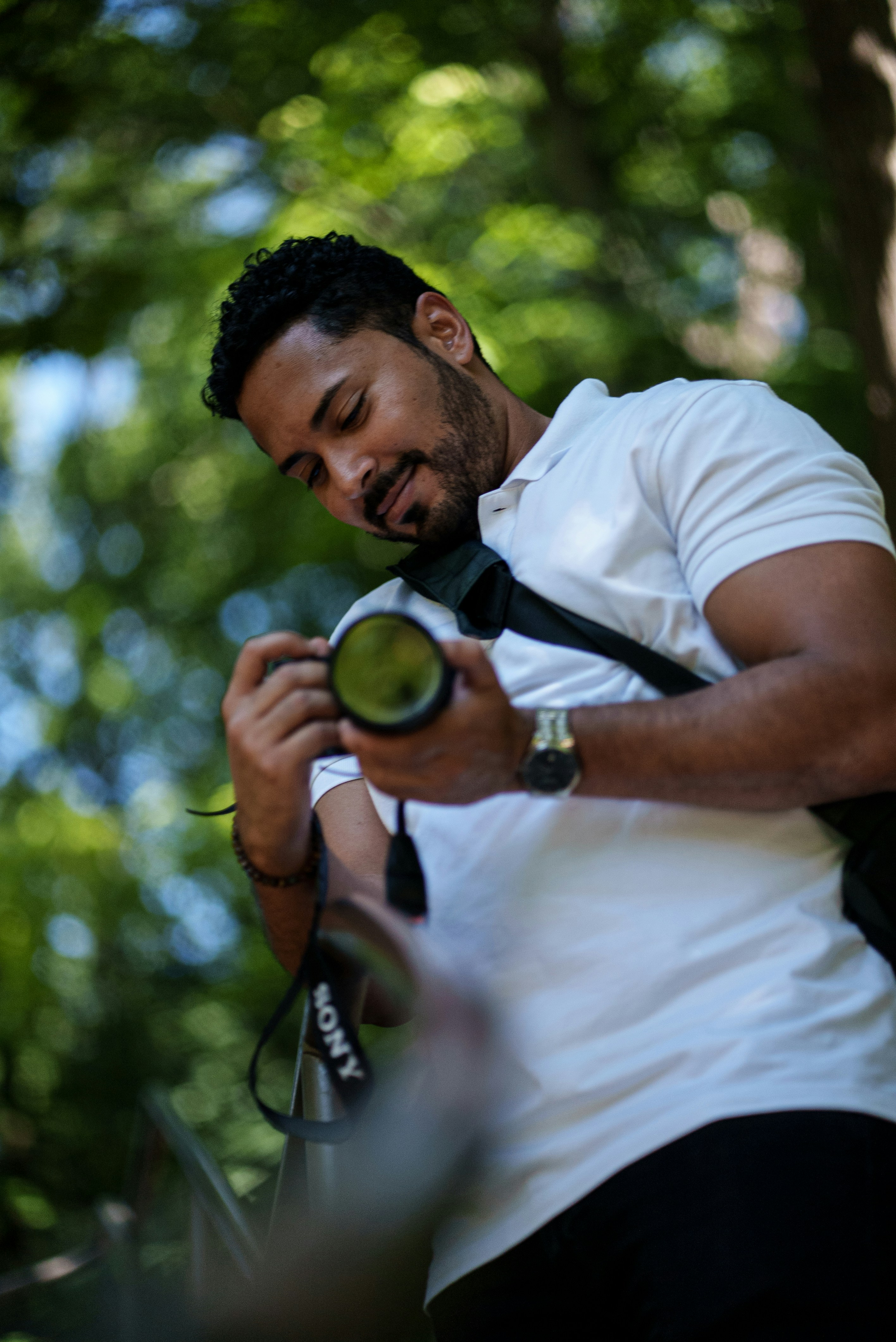 homme en t-shirt blanc tenant un ornement rond vert