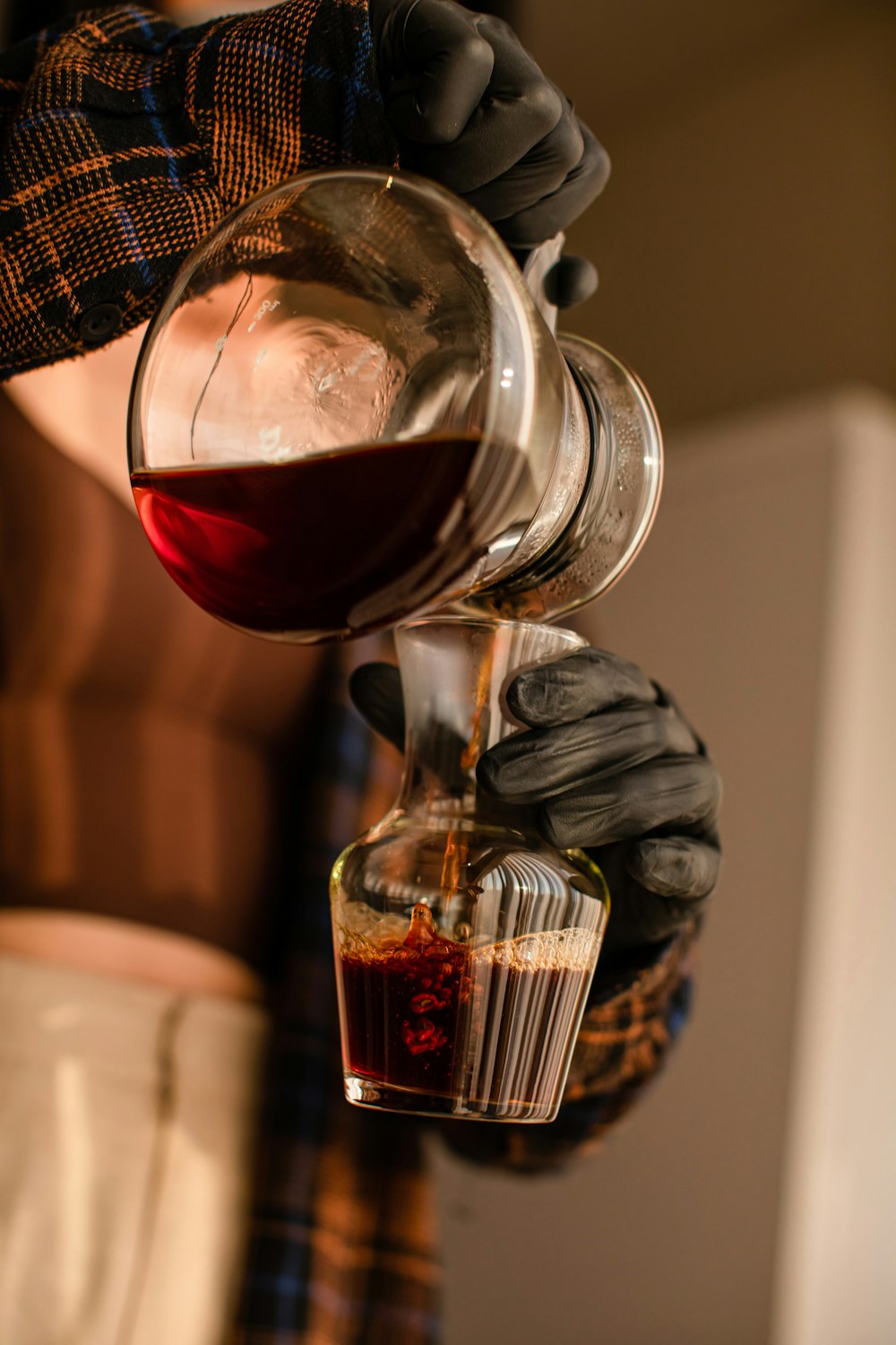 a person pouring a drink into a glass