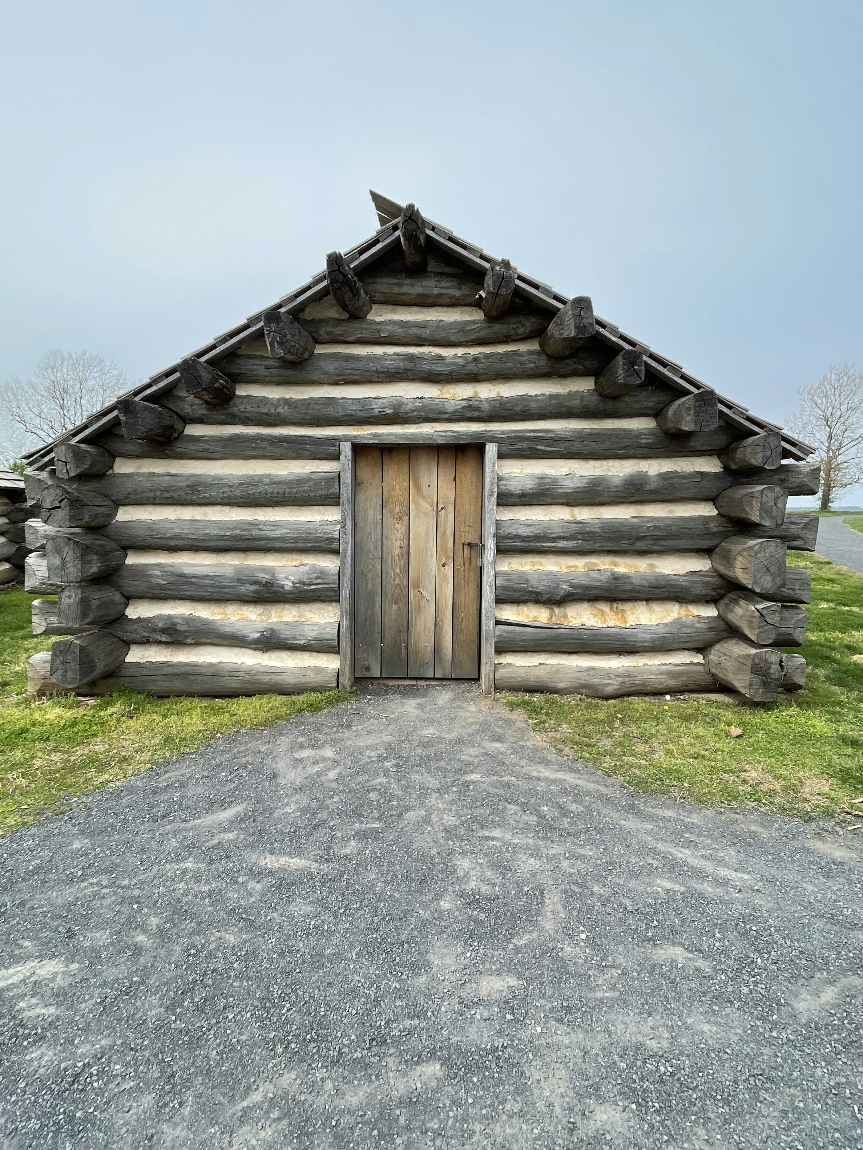 brown wooden house on green grass field during daytime