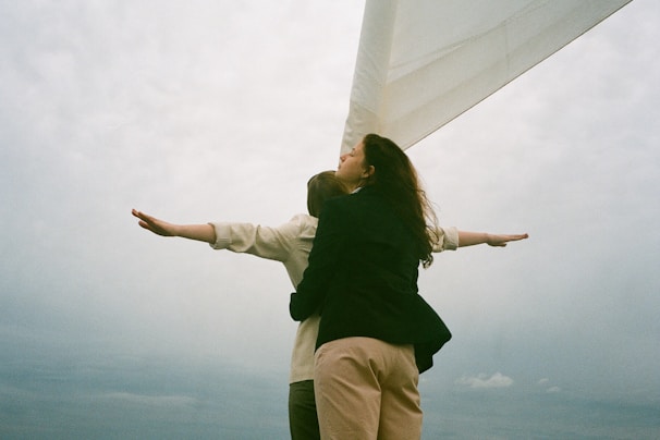 A couple relaxing on a boat with the wind in their hair.