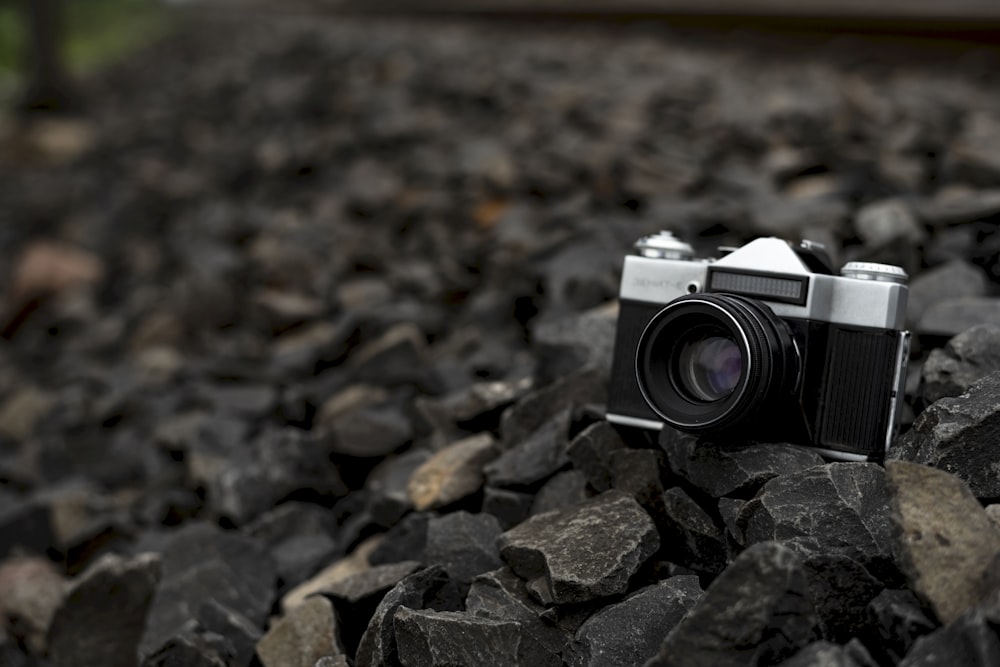 black and silver dslr camera on rocky ground