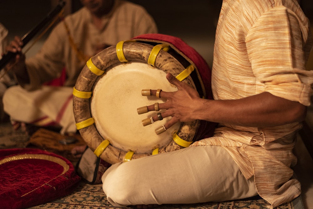 person in white long sleeve shirt playing drum