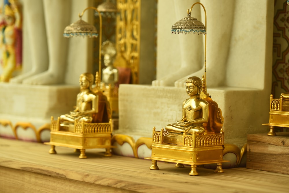 estatueta dourada de buddha na mesa branca