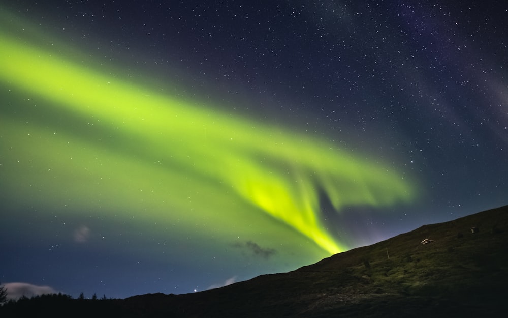 green aurora lights over the mountain