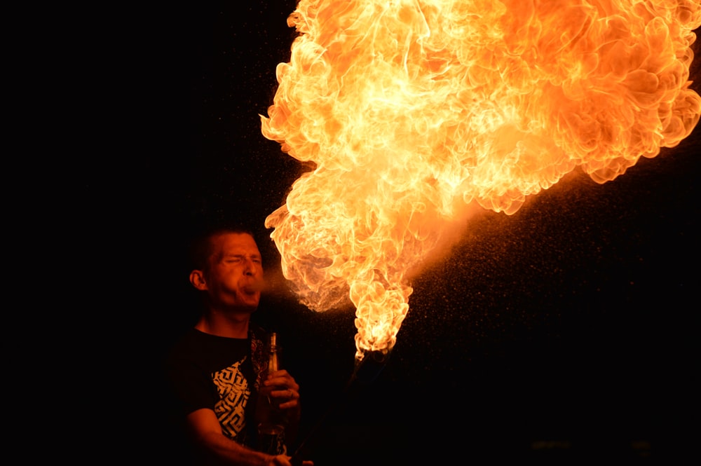 Hombre con camisa negra sosteniendo fuego