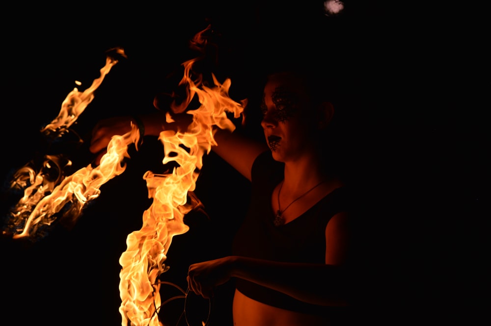 woman in black tank top holding fire
