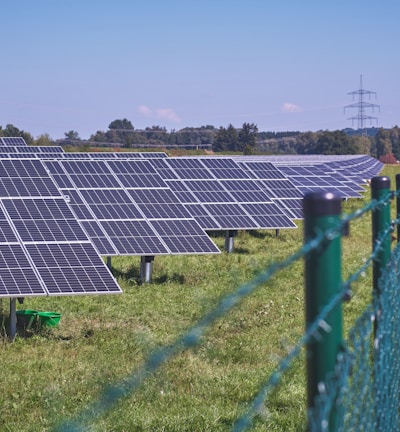 solar panels on green grass field under blue sky during daytime