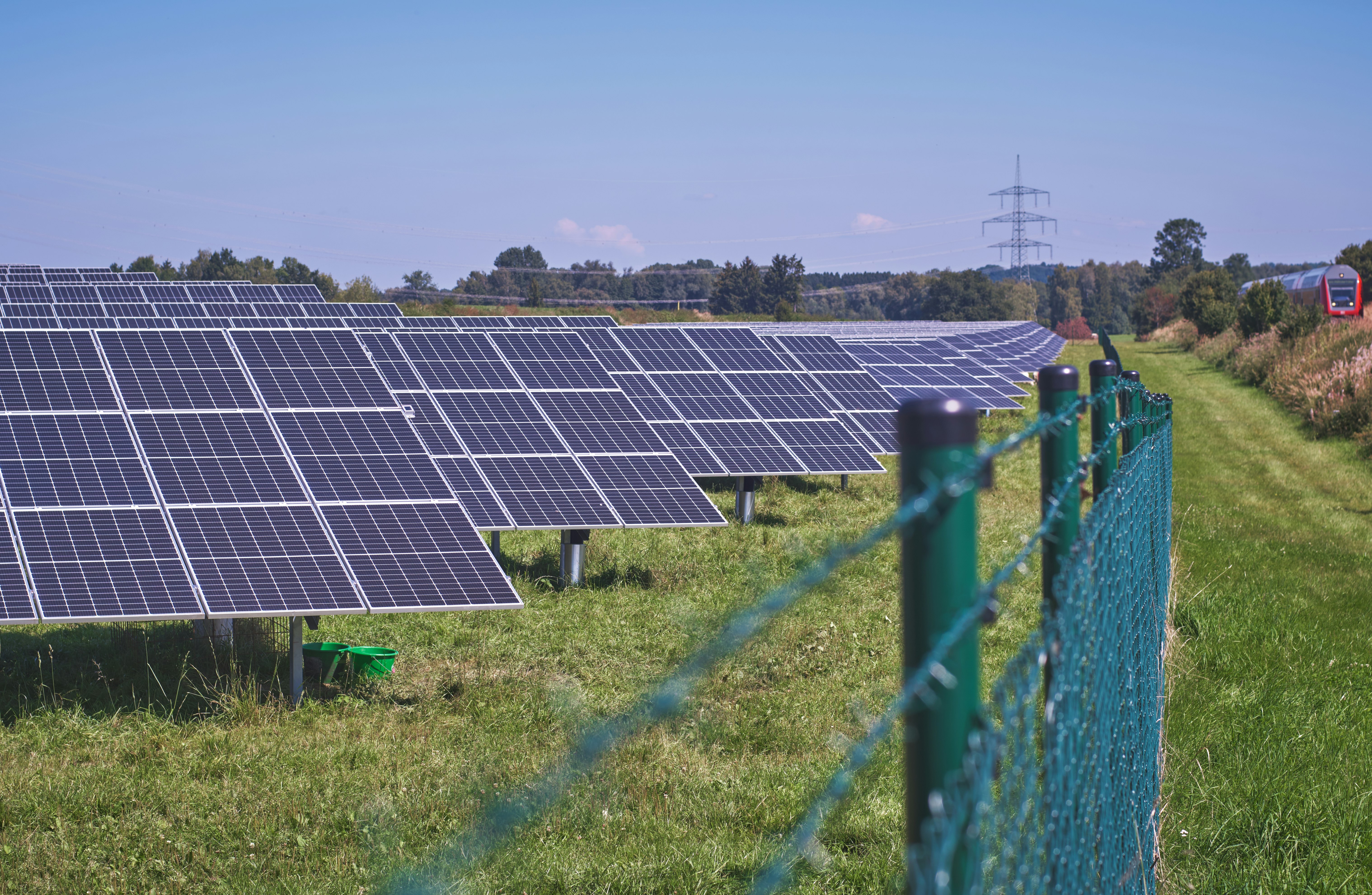 solar panels on green grass field under blue sky during daytime