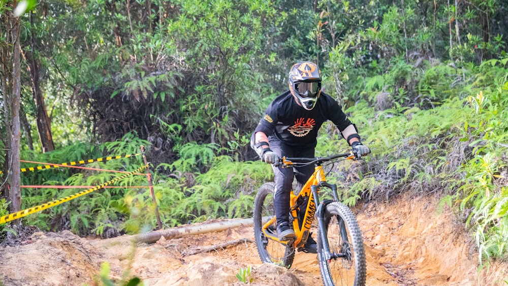 man in black helmet riding on black and yellow mountain bike