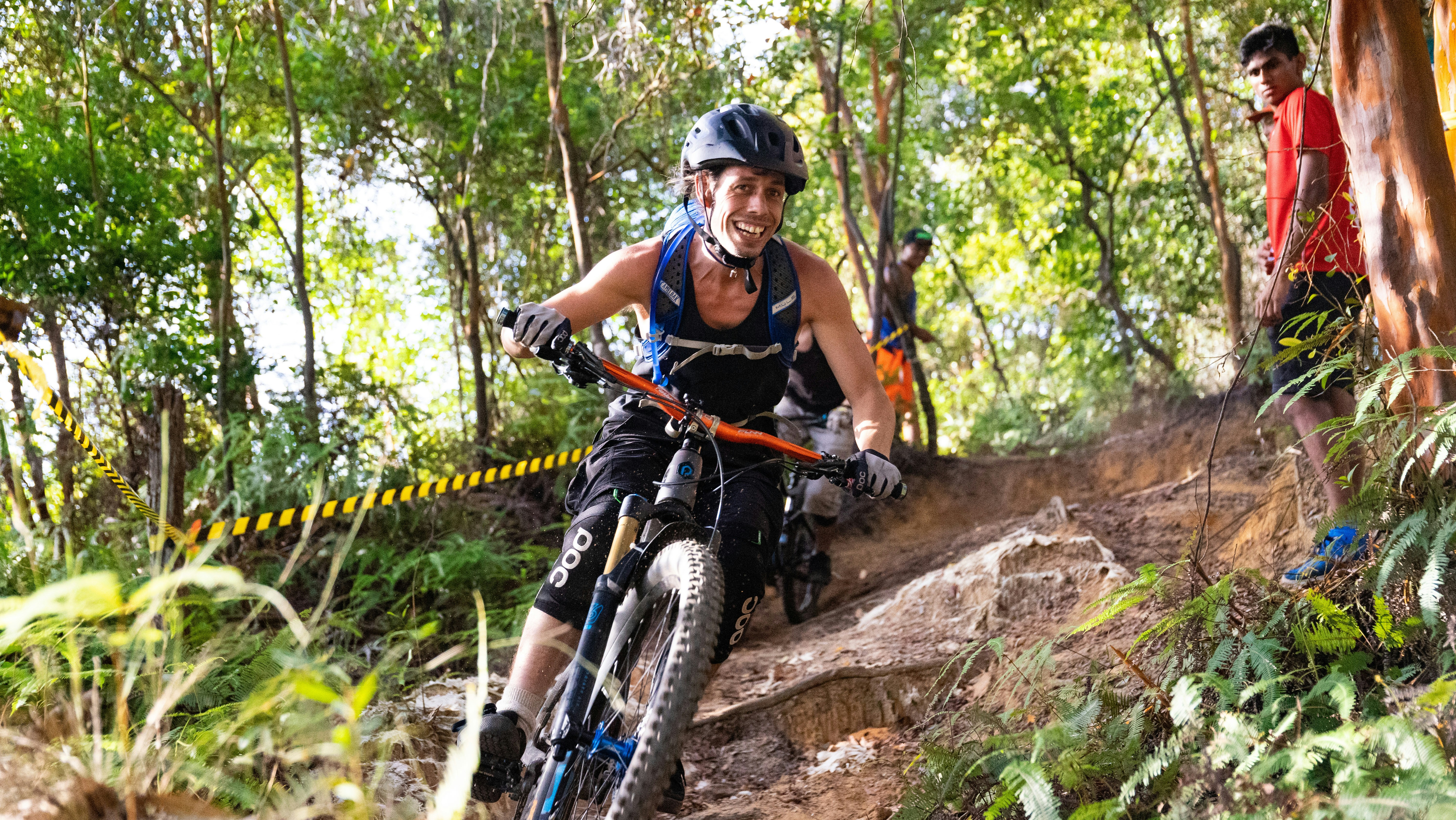 man in black tank top riding black mountain bike