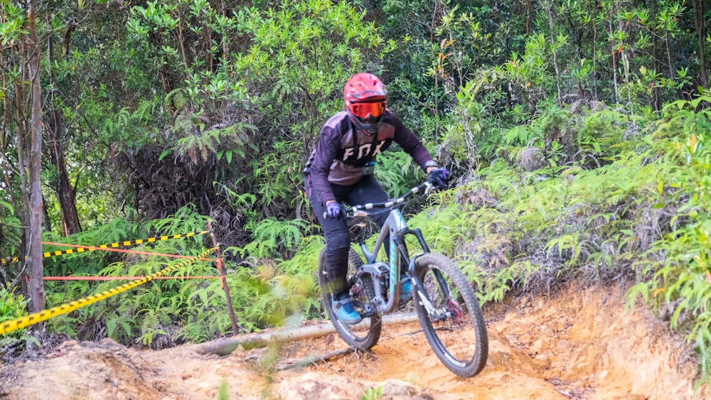 man in black jacket riding blue mountain bike