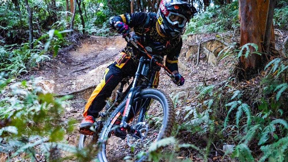 man in black and yellow jacket riding on mountain bike