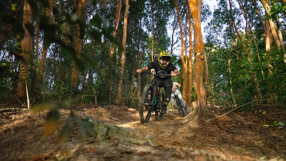 man riding on motocross dirt bike in the woods during daytime