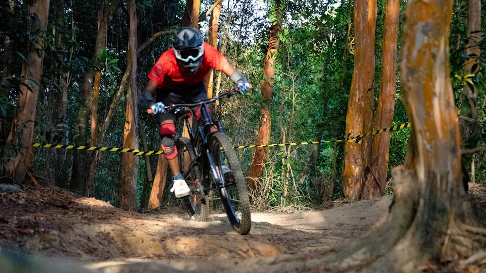 man in black and red helmet riding on black and red mountain bike