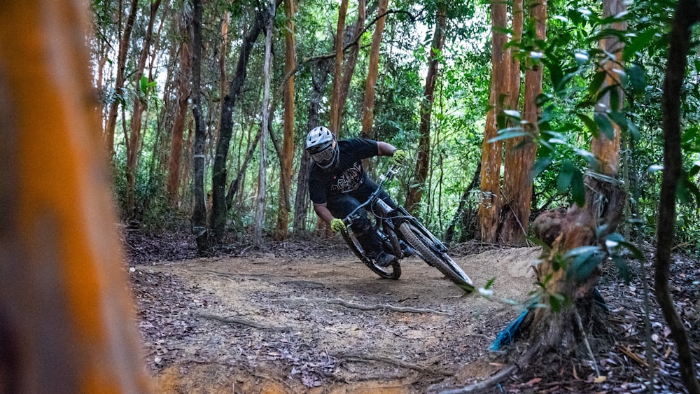 man in black helmet riding motocross dirt bike in forest during daytime