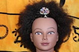 Close-up of a silky, curly wig styled on a mannequin head.