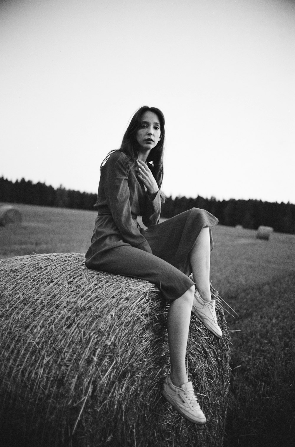 woman in black long sleeve dress sitting on brown grass field